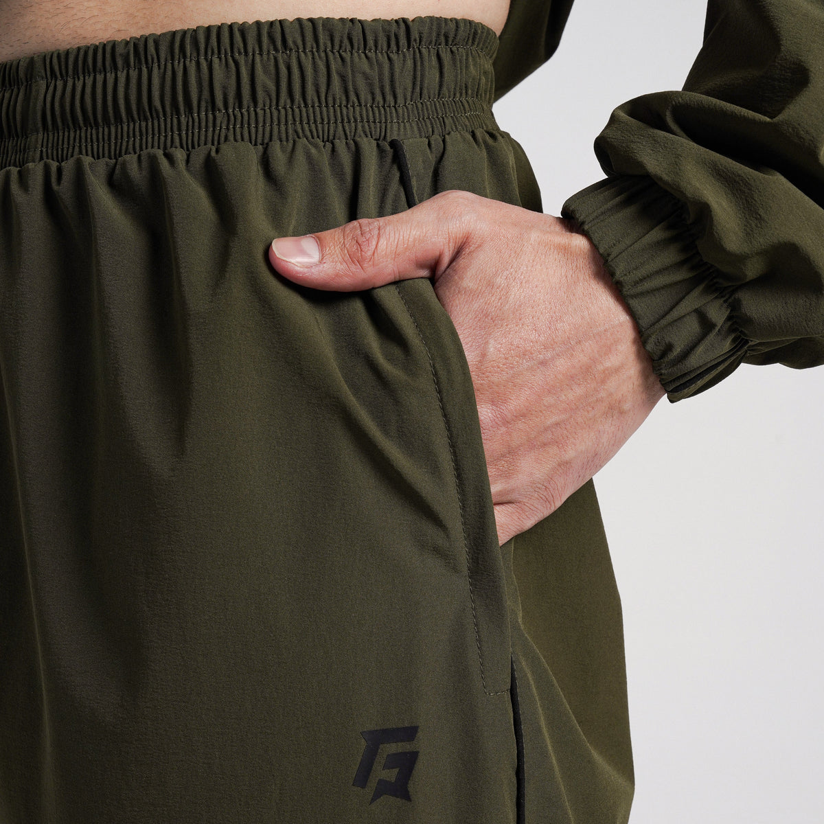 Close-up stitching detail on Olive Maxout Track Pants for men